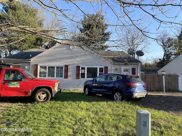 bungalow-style house featuring a front lawn and fence