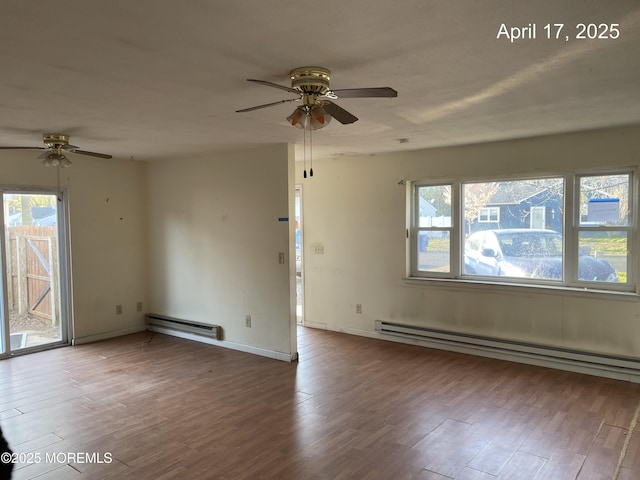 empty room with baseboard heating, baseboards, a ceiling fan, and wood finished floors