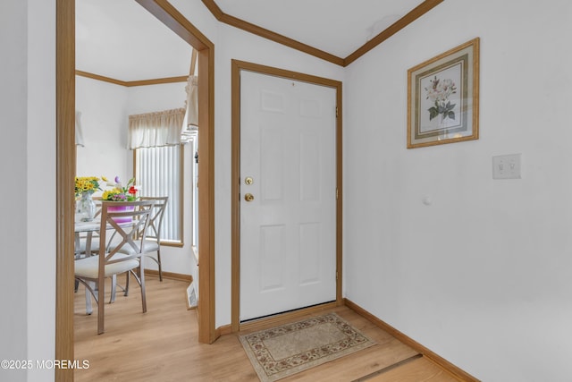 entrance foyer with baseboards, ornamental molding, and light wood-style flooring