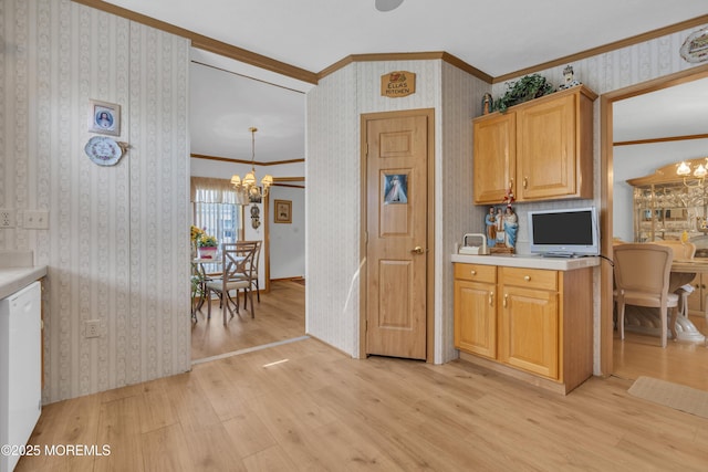 kitchen with light wood finished floors, a chandelier, white dishwasher, crown molding, and light countertops