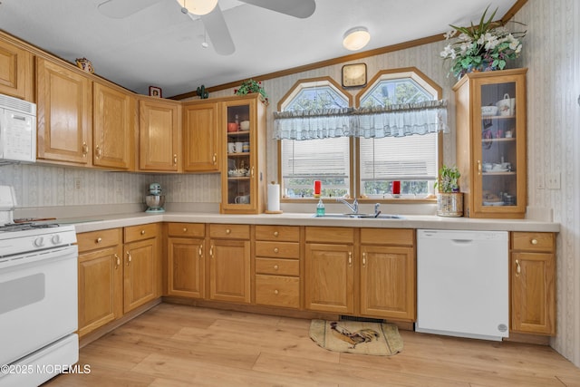 kitchen featuring crown molding, a sink, wallpapered walls, white appliances, and ceiling fan