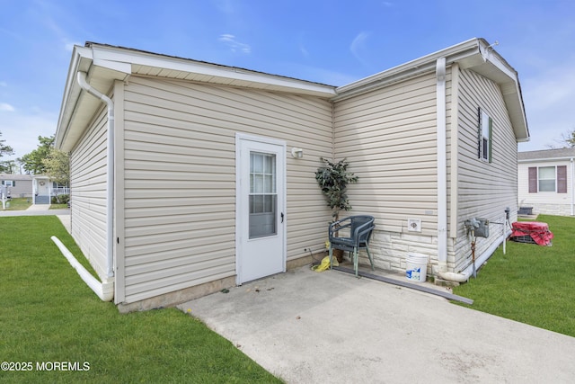 rear view of property featuring a lawn and a patio
