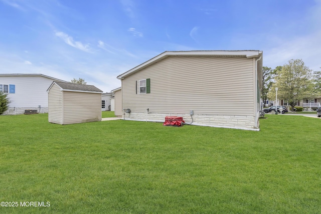 back of house featuring an outdoor structure, central AC unit, a yard, and a storage unit