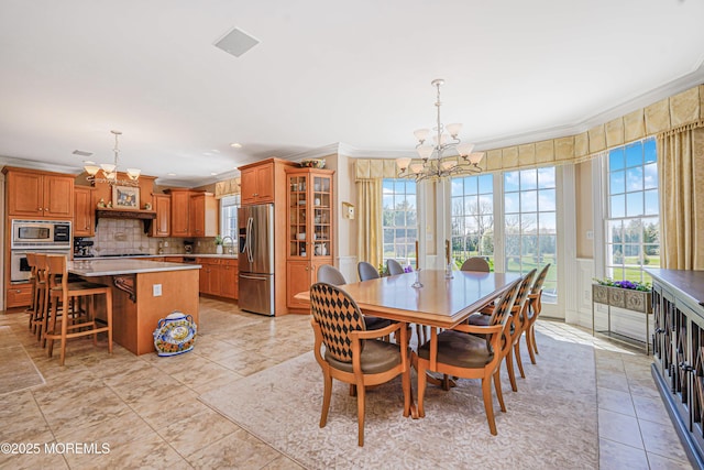dining space featuring crown molding and a notable chandelier