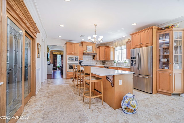 kitchen with crown molding, an inviting chandelier, light countertops, a sink, and stainless steel appliances