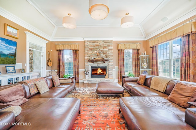 living room featuring ornamental molding, a healthy amount of sunlight, and a fireplace