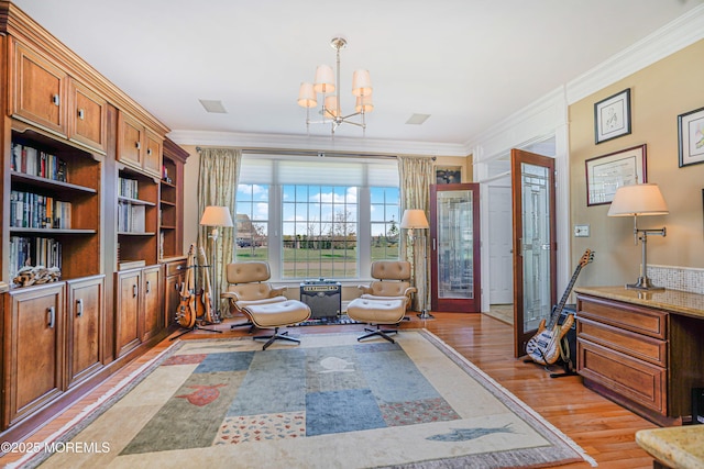 living area with an inviting chandelier, ornamental molding, and light wood finished floors