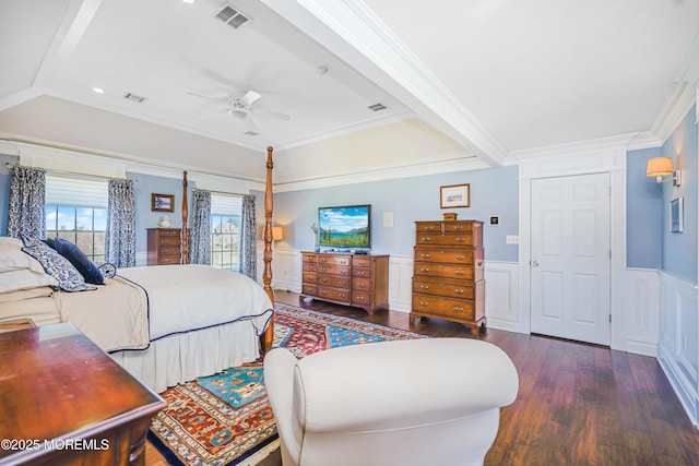 bedroom with ceiling fan, wainscoting, wood finished floors, visible vents, and ornamental molding