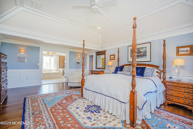 bedroom with crown molding, visible vents, wainscoting, and wood finished floors