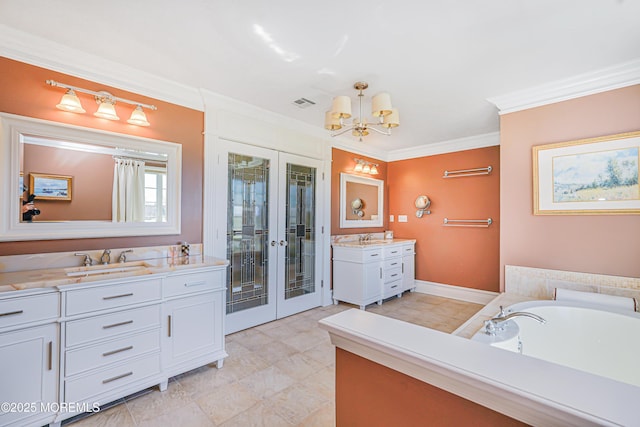 bathroom featuring crown molding, two vanities, a chandelier, french doors, and a sink