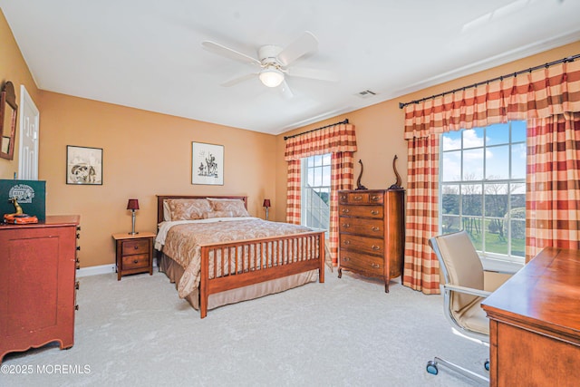 carpeted bedroom with baseboards, a ceiling fan, and visible vents