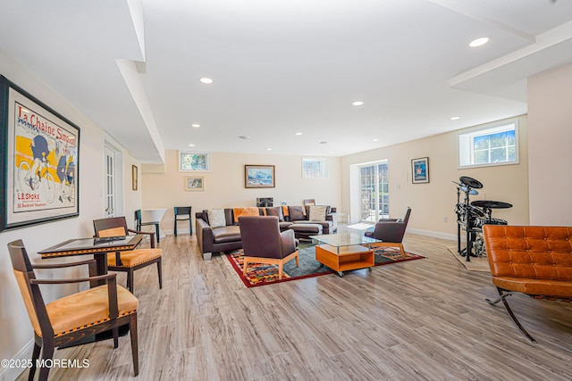 living room featuring baseboards, recessed lighting, and light wood finished floors