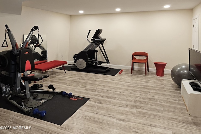 workout room with recessed lighting, baseboards, and wood finished floors
