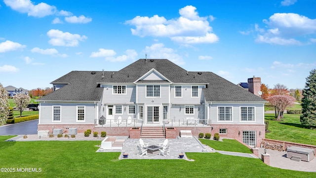rear view of house featuring a fire pit, a patio, a chimney, brick siding, and a yard