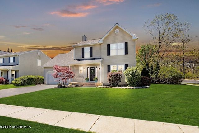 traditional-style house featuring an attached garage, a yard, driveway, and a chimney