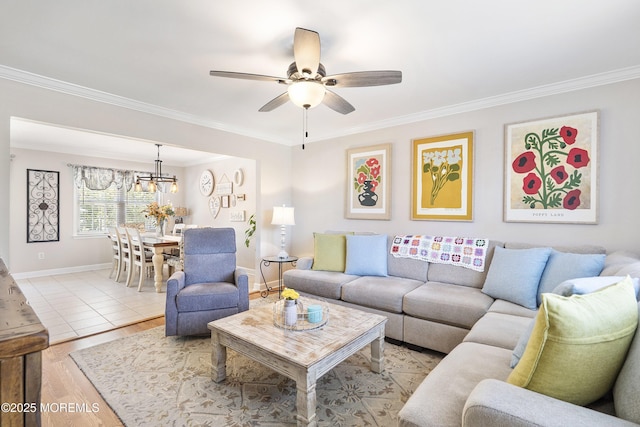 living room featuring crown molding, a ceiling fan, and light wood-style floors