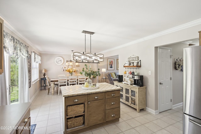 kitchen featuring light tile patterned floors, light countertops, crown molding, and freestanding refrigerator