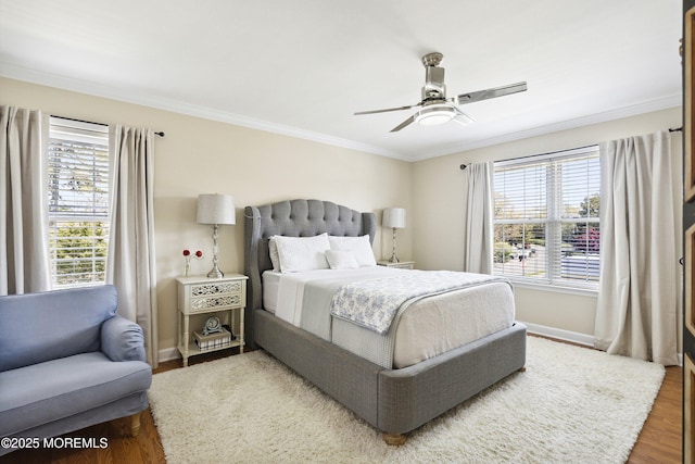 bedroom with baseboards, ornamental molding, wood finished floors, and multiple windows