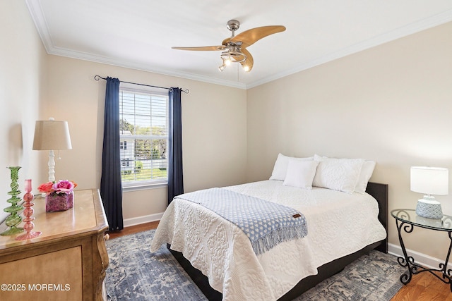 bedroom featuring crown molding, baseboards, and wood finished floors