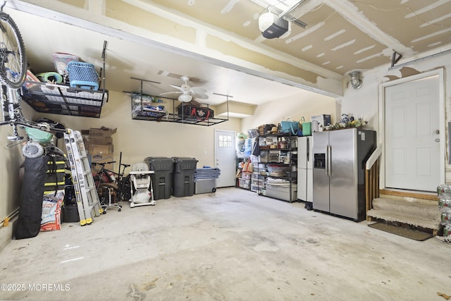 garage featuring stainless steel refrigerator with ice dispenser, a garage door opener, and ceiling fan