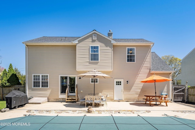back of house with entry steps, a fenced in pool, fence private yard, and a patio