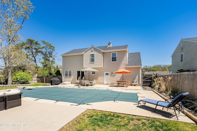 back of property featuring a fenced in pool, a fenced backyard, and a patio area