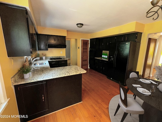 11 Green Hills Rd, East Brunswick, NJ 08816 - kitchen with under cabinet range hood, a sink, light wood-style floors, black fridge with ice dispenser, and gas stovetop