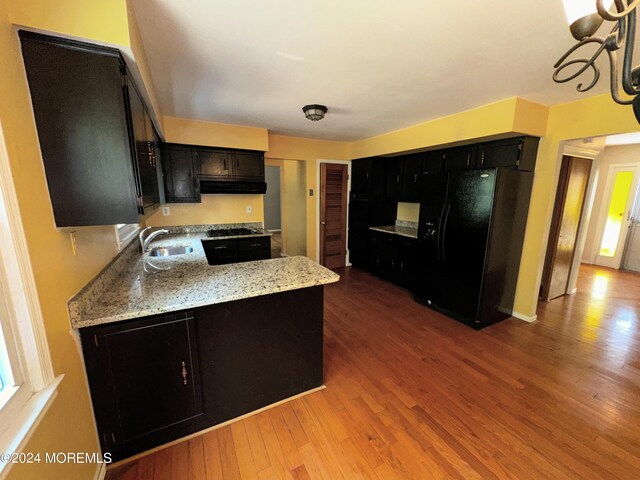11 Green Hills Rd, East Brunswick, NJ 08816 - kitchen with dark cabinets, under cabinet range hood, a sink, and black fridge