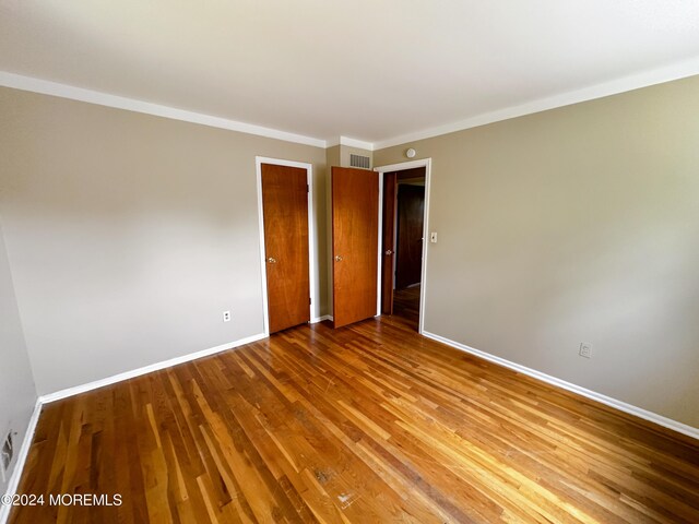 11 Green Hills Rd, East Brunswick, NJ 08816 - spare room with baseboards, ornamental molding, wood finished floors, and visible vents