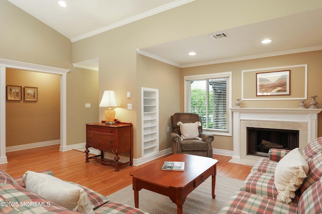 living room with light wood finished floors, crown molding, visible vents, and baseboards