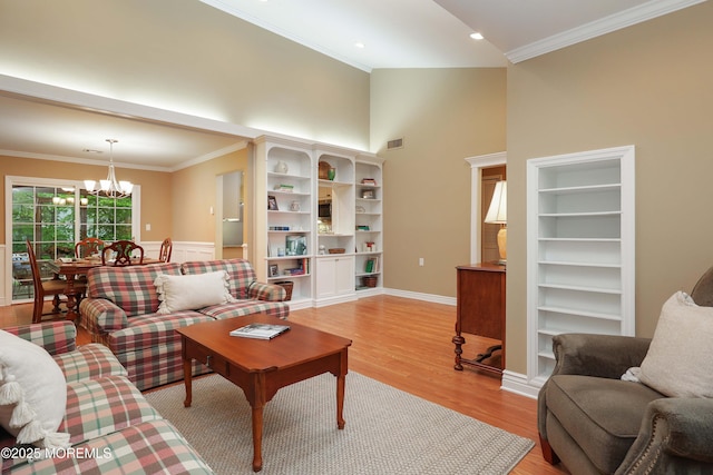 living area with ornamental molding, a notable chandelier, light wood-type flooring, and built in shelves