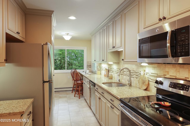 kitchen with cream cabinetry, stainless steel appliances, a baseboard heating unit, and a sink