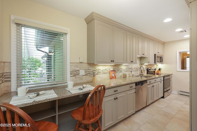 kitchen with a sink, visible vents, baseboard heating, backsplash, and appliances with stainless steel finishes