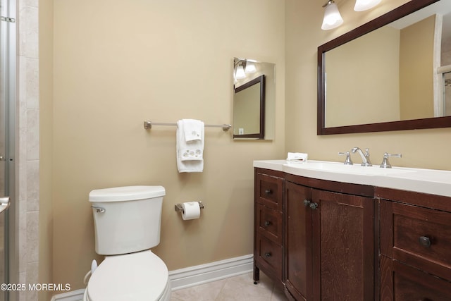 bathroom with vanity, toilet, baseboards, and tile patterned floors