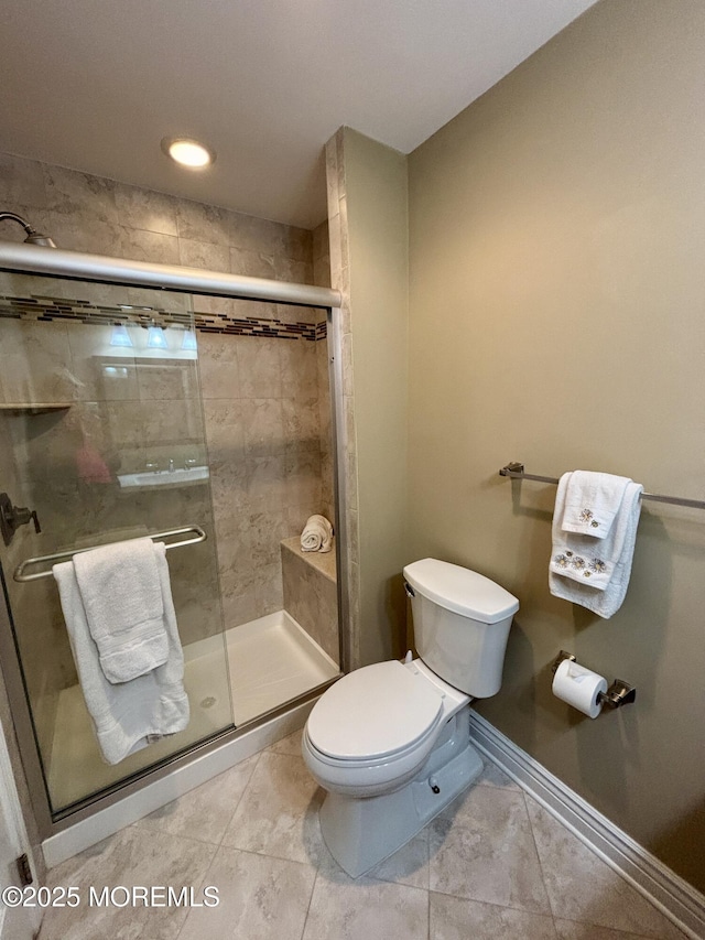 full bath featuring toilet, tile patterned flooring, and a stall shower