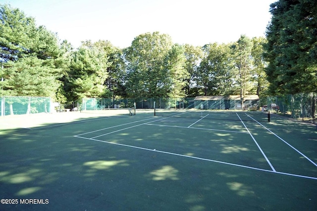 view of tennis court featuring fence
