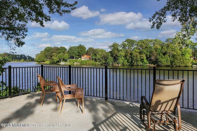 view of patio featuring a water view and a balcony