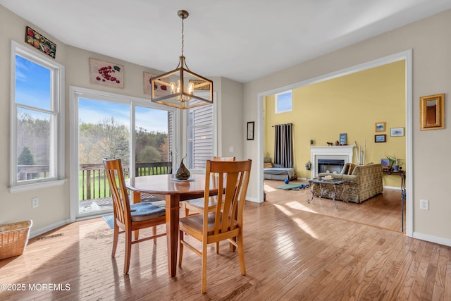 3 Scenic Way, Monroe, NJ 08831 - dining room with light wood finished floors, visible vents, baseboards, a chandelier, and a glass covered fireplace
