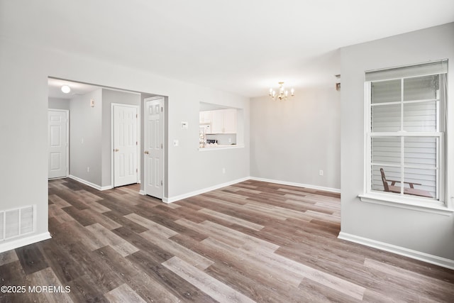 2304 Wendover Dr, Pompton Plains, NJ 07444 - unfurnished living room with baseboards, a notable chandelier, wood finished floors, and visible vents