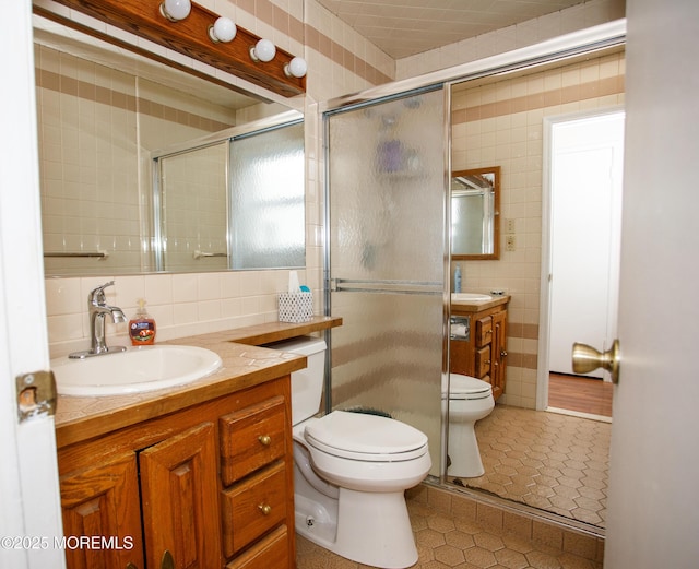 full bathroom featuring tile patterned floors, toilet, tile walls, backsplash, and vanity
