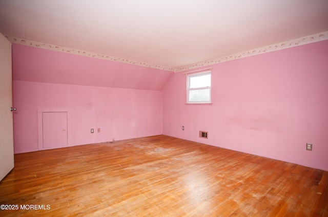 bonus room featuring lofted ceiling, visible vents, and light wood-style flooring
