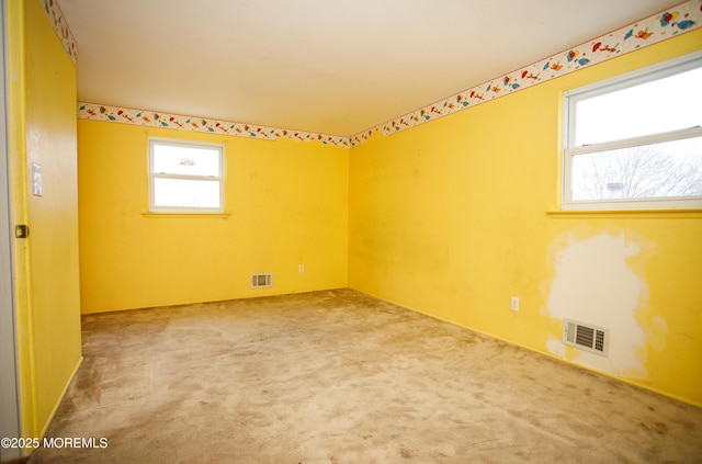carpeted spare room featuring visible vents