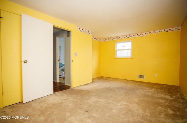 spare room featuring visible vents and carpet flooring