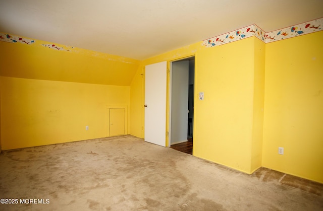 interior space featuring vaulted ceiling and carpet