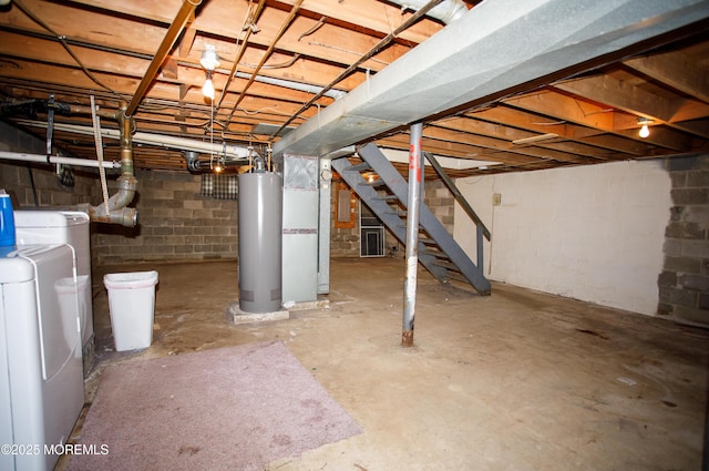 unfinished below grade area featuring water heater, concrete block wall, stairway, and washer / clothes dryer
