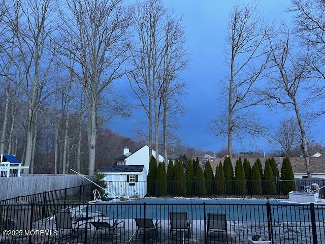 snow covered pool with fence and a fenced in pool