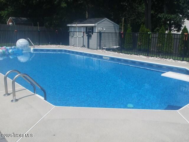view of swimming pool featuring fence, a fenced in pool, and a diving board