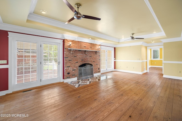 159 Sprague Ave, West Creek, NJ 08092 - unfurnished living room featuring visible vents, a fireplace, plenty of natural light, a tray ceiling, and a ceiling fan