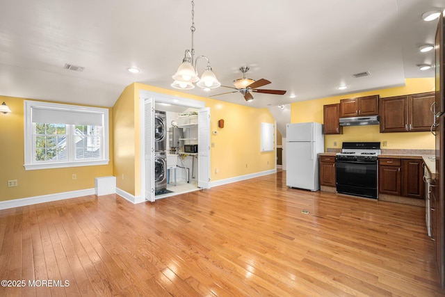 159 Sprague Ave, West Creek, NJ 08092 - kitchen with freestanding refrigerator, stacked washer / dryer, under cabinet range hood, visible vents, and gas range oven