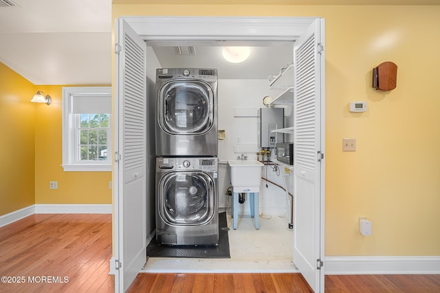 159 Sprague Ave, West Creek, NJ 08092 - clothes washing area featuring laundry area, stacked washer and clothes dryer, wood finished floors, baseboards, and electric panel